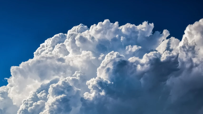 a plane flying through a cloud filled blue sky, by Hans Schwarz, pexels, romanticism, towering cumulonimbus clouds, looking off to the side, cumulus, loots of clouds