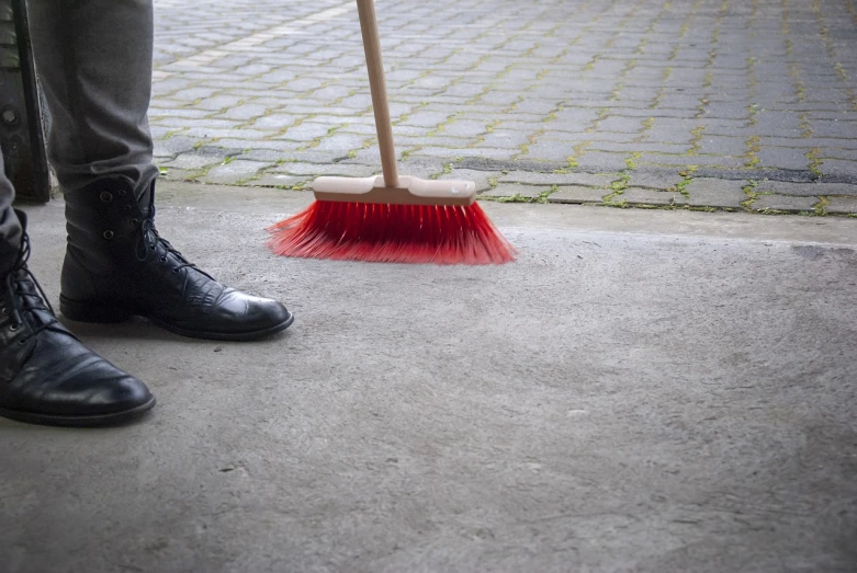 a person standing on a sidewalk with a broom, plasticien, 8 0 mm photo