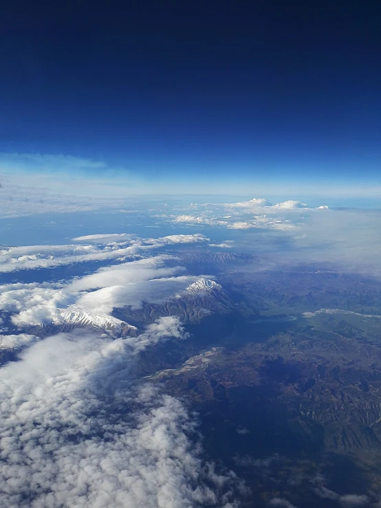 a view of mountains and clouds from an airplane, flickr, precisionism, mount fuji on the background, space photo, near lake baikal, today\'s featured photograph 4k