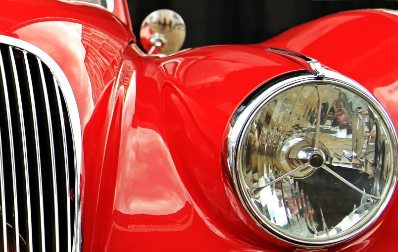 a close up of the front of a red car, a photo, by Hans Schwarz, photorealism, photorealism. trending on flickr, car lights, highly polished, vintage car