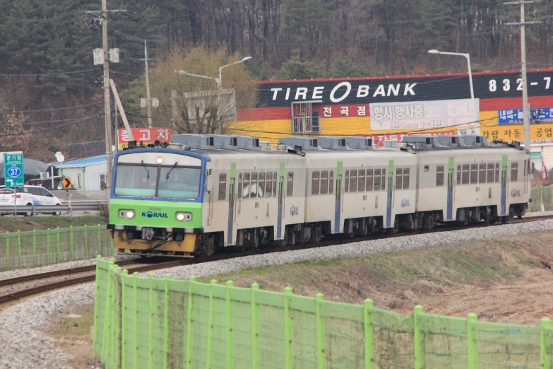 a large long train on a steel track, inspired by Choi Buk, flickr, mingei, traditional korean city, name is tripmachine, square, suburban