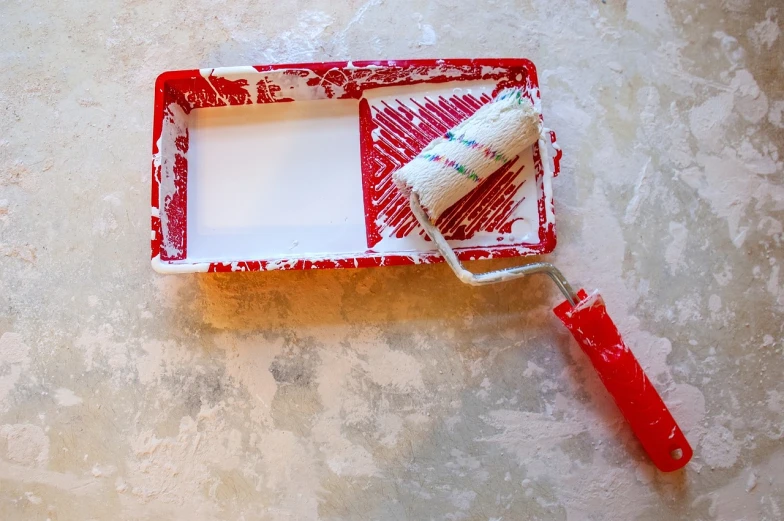 a paint roller sitting on top of a red tray, a minimalist painting, action painting, professional work, indoor, wonderful scene, plaster