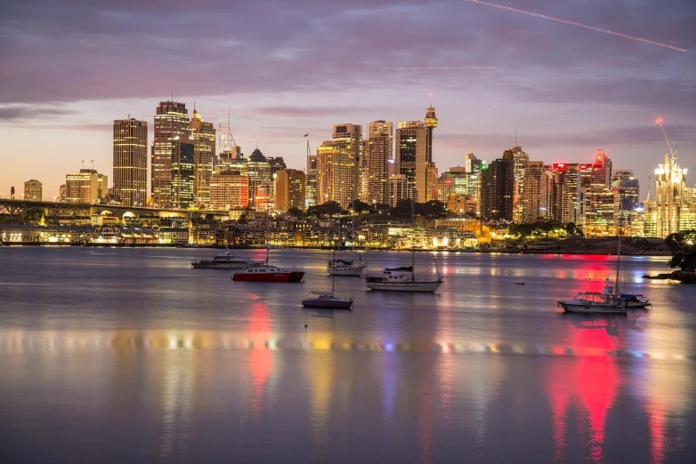 a group of boats floating on top of a body of water, inspired by Sydney Carline, pexels, twilight skyline, iso 1 0 0 wide view, vibrant backlit, tony roberts