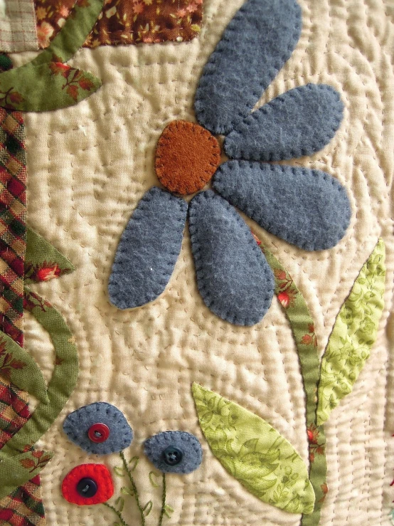 a close up of a quilt with a flower on it, by Anita Kunz, flickr, folk art, mediumslateblue flowers, closeup of an adorable, felt, daisy