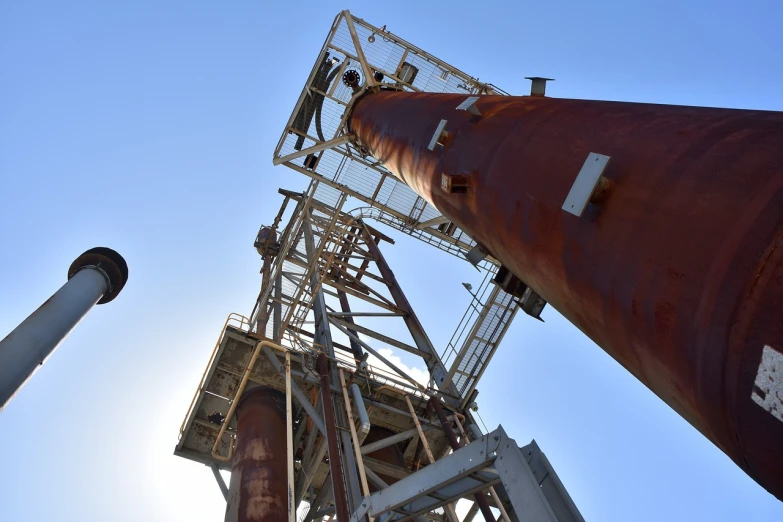 a tall metal structure with a blue sky in the background, shutterstock, industrial rusty pipes, deep shafts, portlet photo