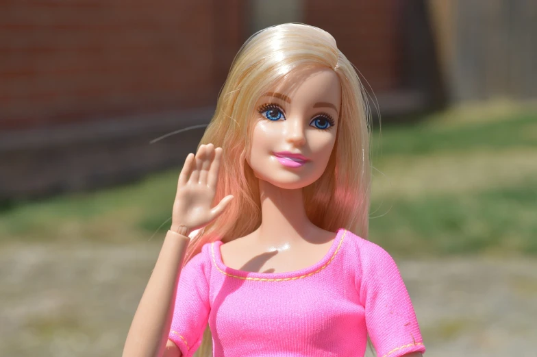 a close up of a barbie doll wearing a pink dress, by Tom Carapic, pixabay, waving at the camera, bosnian, very sunny, high quality image