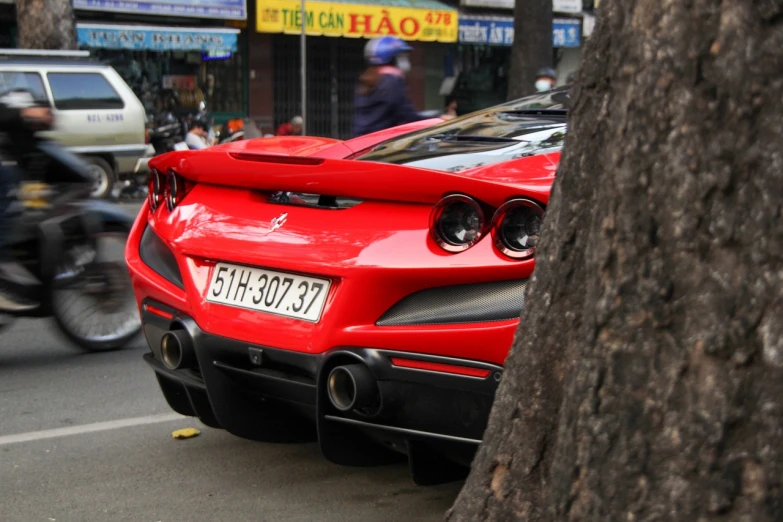 a red sports car parked next to a tree, les automatistes, in style of lam manh, close-up shot from behind, lunar busy street, f12