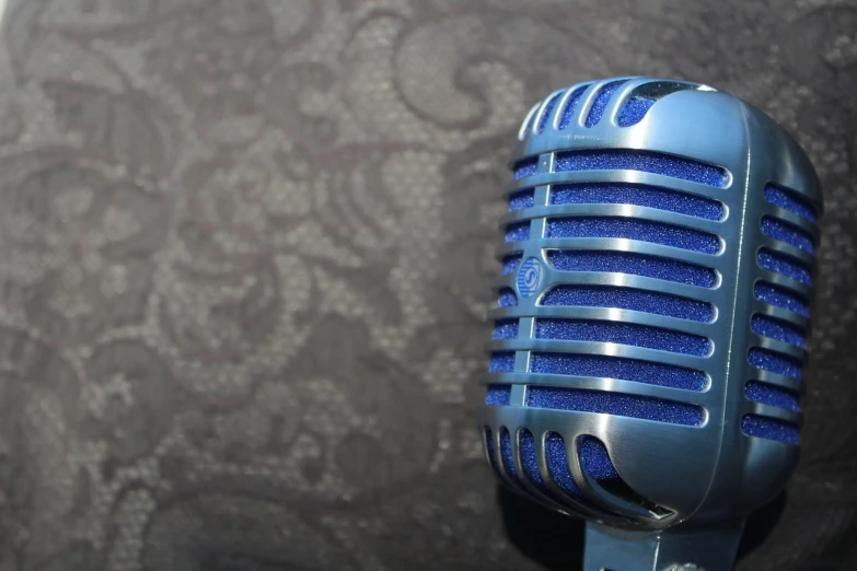 a blue microphone sitting on top of a table, a portrait, by Tom Carapic, pixabay, on a velvet table cloth, electric wallpaper, background image, greg rutwoski