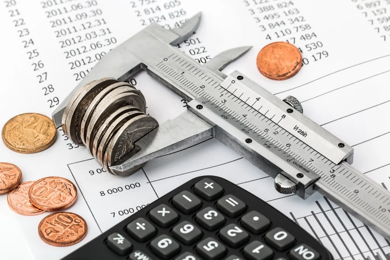 a calculator sitting on top of a calculator next to a calculator, by Zoltán Nuridsány, pixabay, analytical art, coins, 2019 trending photo, maintenance photo, stock image