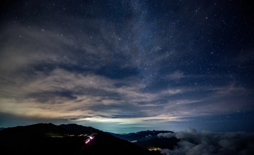 a person standing on top of a mountain under a night sky, by Etienne Delessert, happening, night sky with clouds and stars, japan at night, 3 meters, emitting spore clouds