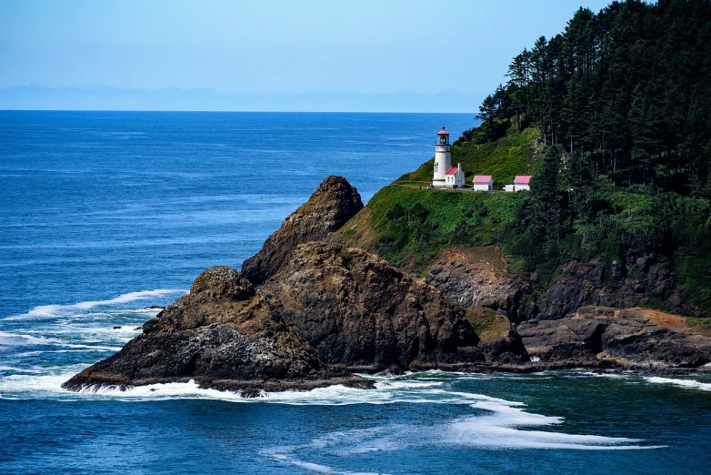 a lighthouse sitting on top of a cliff next to the ocean, a picture, by Jim Nelson, shutterstock, pacific northwest coast, the photo was taken from afar, landscape photo, stock photo