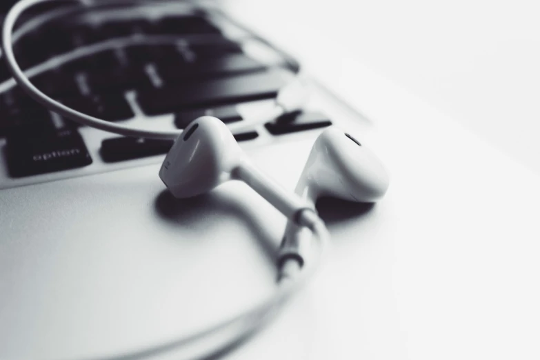 a pair of ear buds sitting on top of a laptop, minimalism, white tones, iphone photo, closeup photo, connected