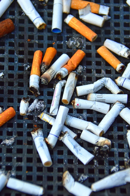 a pile of cigarettes sitting on top of a grill, a portrait, pixabay, auto-destructive art, stock and two smoking barrels, they are all laying down, 2000s photo, istockphoto