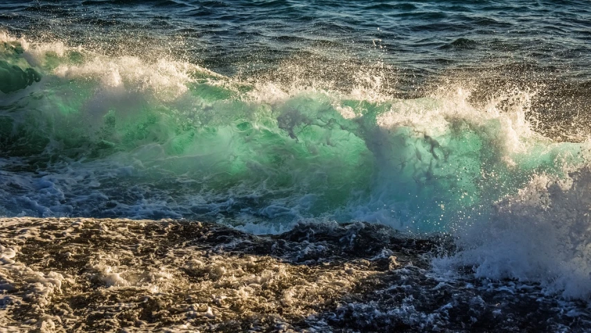 a man riding a wave on top of a surfboard, a picture, by Robert Griffier, shutterstock, fine art, tones of blue and green, waves crashing at rocks, glistening seafoam, dramatic ”