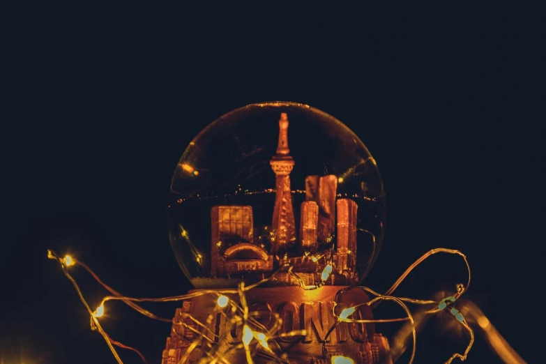 a close up of a light bulb with a city in the background, a tilt shift photo, unsplash contest winner, magical realism, in a japanese town at night, snowglobe, disco ball, shrines