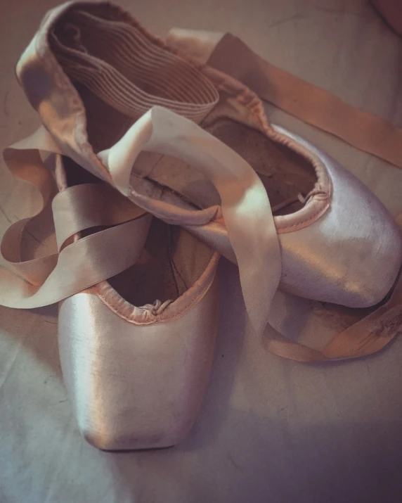 a close up of a pair of ballet shoes, a still life, by Béla Kondor, pexels, arabesque, faded glow, ribbons, really realistic, end of the day