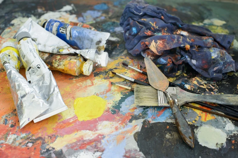 a bunch of paint brushes sitting on top of a table, a photorealistic painting, inspired by Lovis Corinth, pexels, action painting, tools and junk on the ground, oil on canvas 4k, 4k photograph of painting, prussian blue and azo yellow