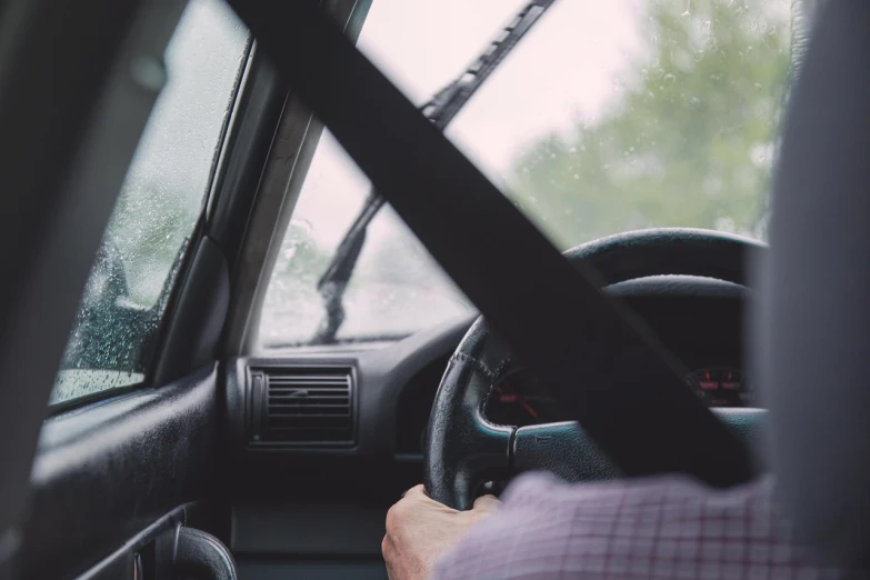 a man driving a car in the rain, by Carey Morris, pexels, wielding a crowbar, completely empty, 🚿🗝📝, leather interior