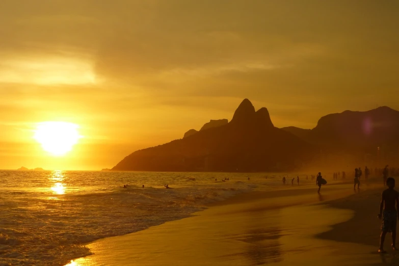 a group of people walking along a beach at sunset, by Felipe Seade, romanticism, christ the redeemer, wikimedia commons, sunset warm spring, rice