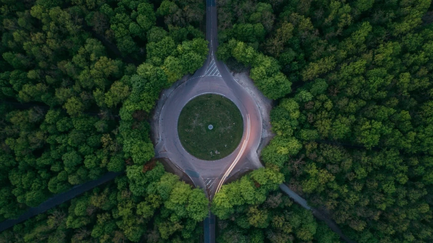 a bird's eye view of a park surrounded by trees, by Adam Marczyński, unsplash contest winner, environmental art, a glowing halo, forest portal, driving, very low - angle