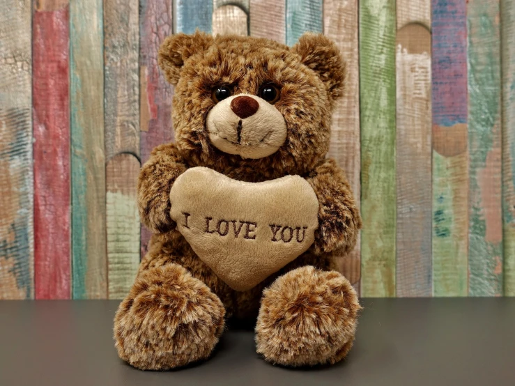 a brown teddy bear sitting on top of a table, a picture, by Linda Sutton, pixabay, hurufiyya, i love you, heart eyes, full subject shown in photo, high resolution product photo