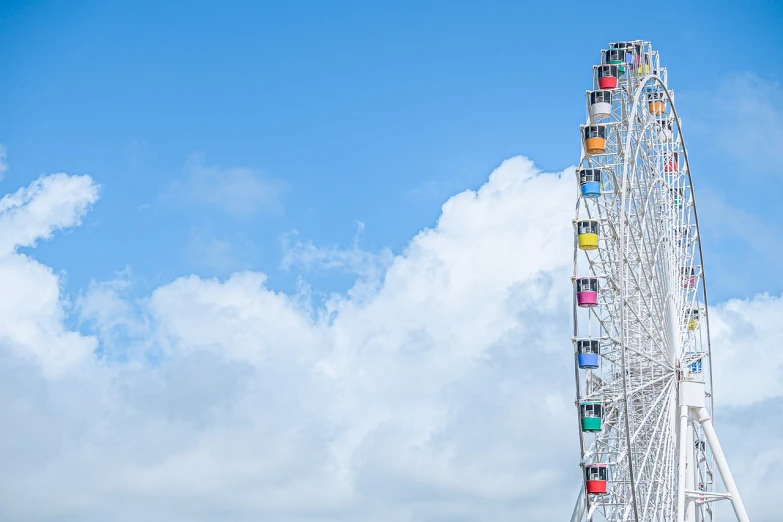 a ferris wheel in front of a cloudy blue sky, a picture, by Okuda Gensō, shutterstock, japan shonan enoshima, colors white!!, shot on sony a 7, lie on white clouds fairyland