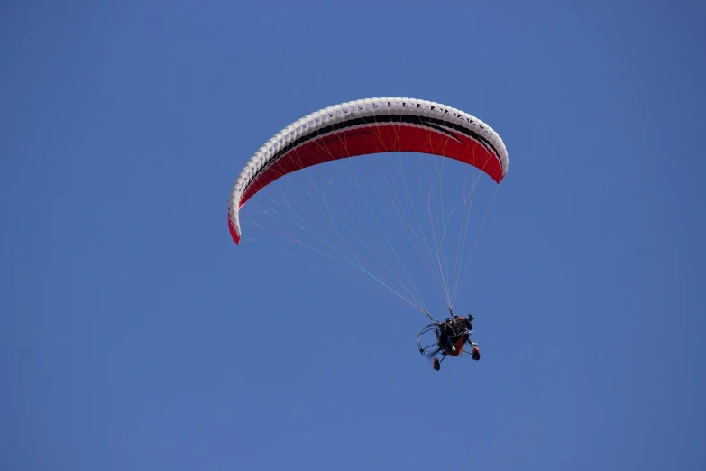 a person that is in the air with a parachute, a picture, figuration libre, telephoto long distance shot, buggy, blue sky above, b - roll