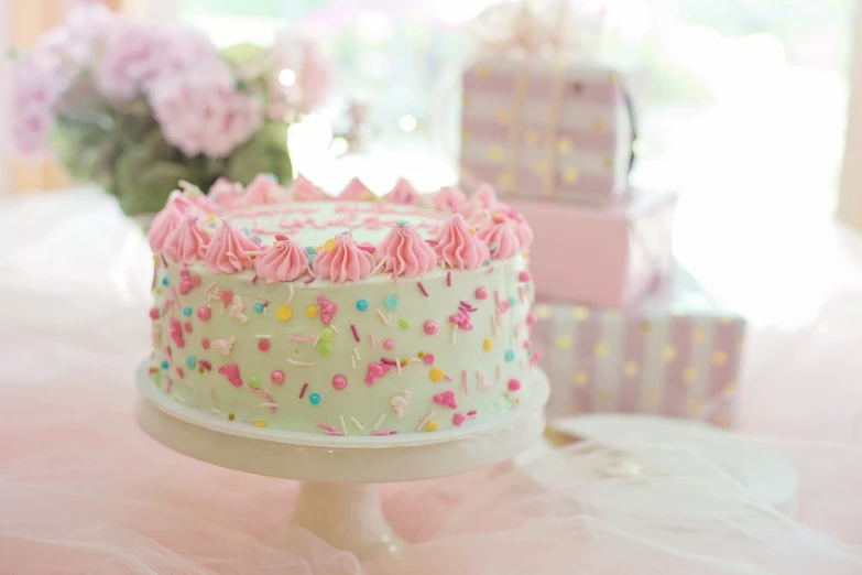 a cake sitting on top of a white cake plate, by Alice Mason, pexels, pink and green, gifts, food particles, fairycore