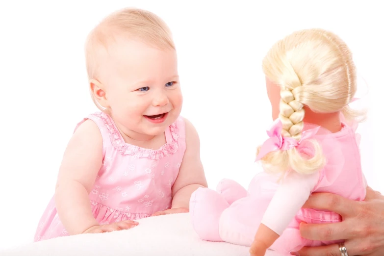 a close up of a person holding a doll, a photo, by Harold Elliott, shutterstock, smiling at each other, beautiful pink little girl, with a white background, softplay