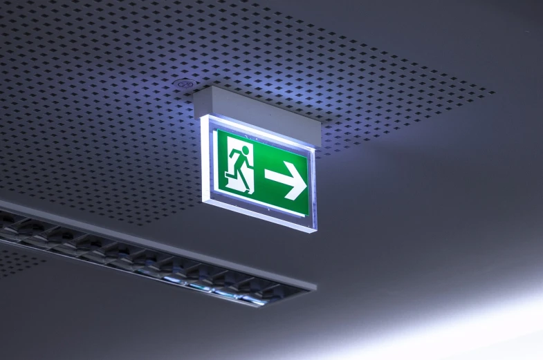 a green fire exit sign mounted to the ceiling, volumetric lighting. fantasy, lightbox, 3 ds max, taken in the night