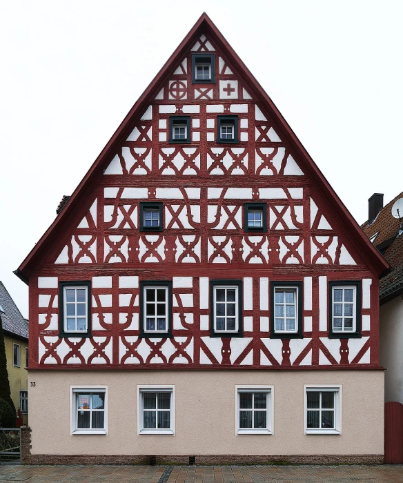 a red and white building with a clock on top of it, by Bernd Fasching, medieval house, symmetrical framing, truss building, wall structure