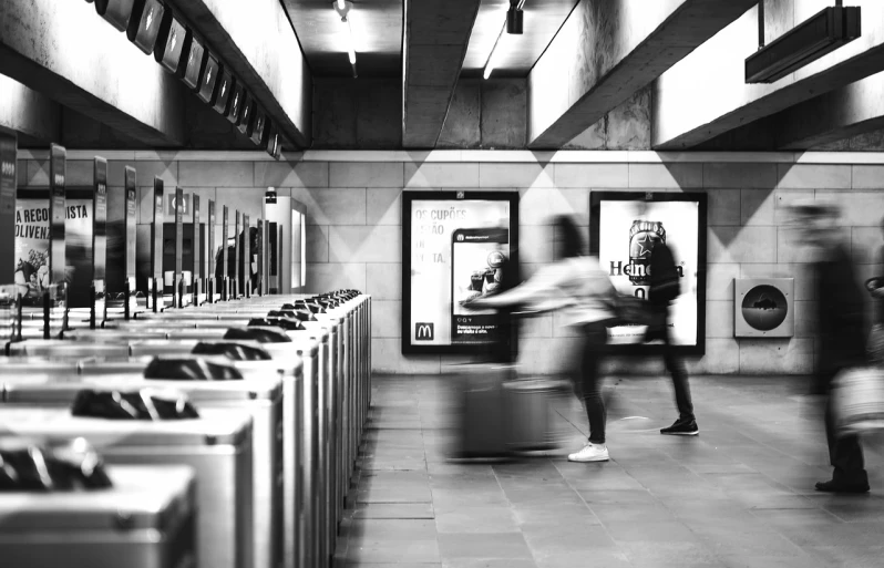 a black and white photo of people in a public restroom, pexels contest winner, happening, london underground tube station, motion blurred background, bags on ground, terminals