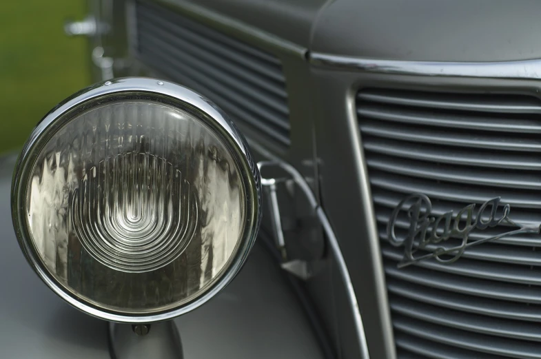 a close up of the front of a vintage car, by David Simpson, photorealism, lighting refraction, captured with sony a3 camera, grayish, 1934