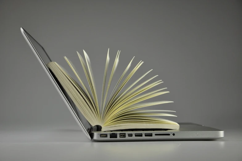 an open book sitting on top of a laptop computer, pixabay, computer art, streamlined spines, épaule devant pose, photograph credit: ap, advert
