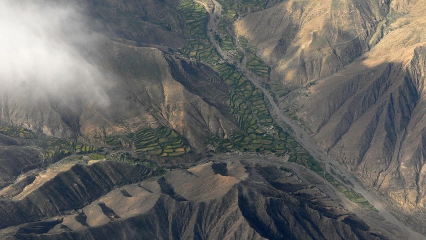 an aerial view of a valley in the mountains, by Daren Bader, flickr, hurufiyya, paddy fields and river flowing, random detail, himalayas, lava rivers