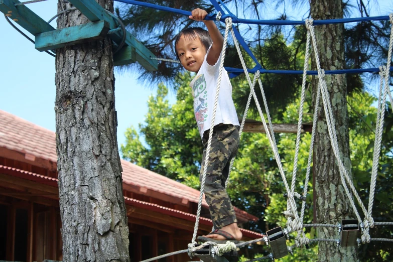 a little girl that is standing on a rope, with matsu pine trees, softplay, scout boy, kuntilanak on tree