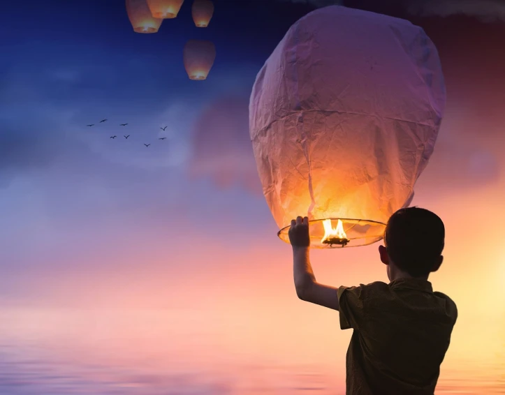 a man holding a sky lantern above his head, a picture, pixabay contest winner, conceptual art, cute boy, looking into the horizon, hot air balloon, holding a torch