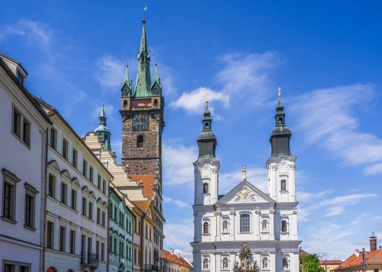 a group of people walking down a street next to tall buildings, a photo, by Sigmund Freudenberger, shutterstock, baroque, in legnica city hall, two organic looking towers, stock photo, holy