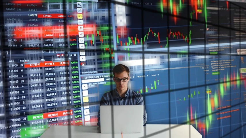 a man sitting in front of a laptop computer, a picture, shutterstock, analytical art, trading stocks, jewish young man with glasses, stacked computer screens, high quality fantasy stock photo