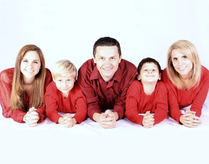 a family posing for a picture in red pajamas, incoherents, lined up horizontally, white and red color scheme, they are all laying down, profile image