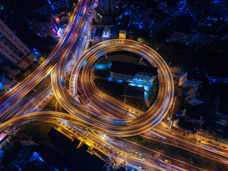 an aerial view of a city at night, pexels, golden curve structure, random circular platforms, freeway, high quality image