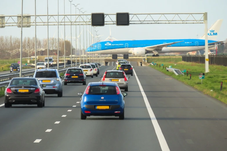 a group of cars driving down a highway, a photo, by Hugo van der Goes, flickr, de stijl, airport, large blue engines, dutch style painting, it is very huge