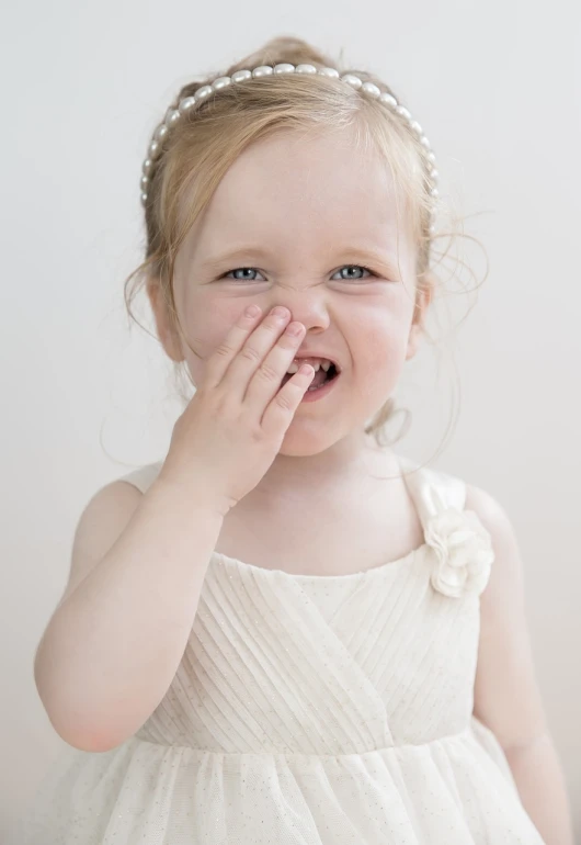 a little girl covering her face with her hands, shutterstock contest winner, wearing stunning ivory dress, happy with his mouth open, she has perfect white teeths, toy commercial photo