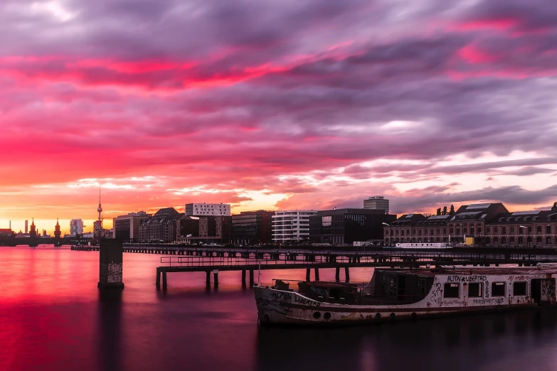 a boat that is sitting in the water, by Jacob Esselens, pexels contest winner, happening, city sunset, purple and scarlet colours, panorama, liege