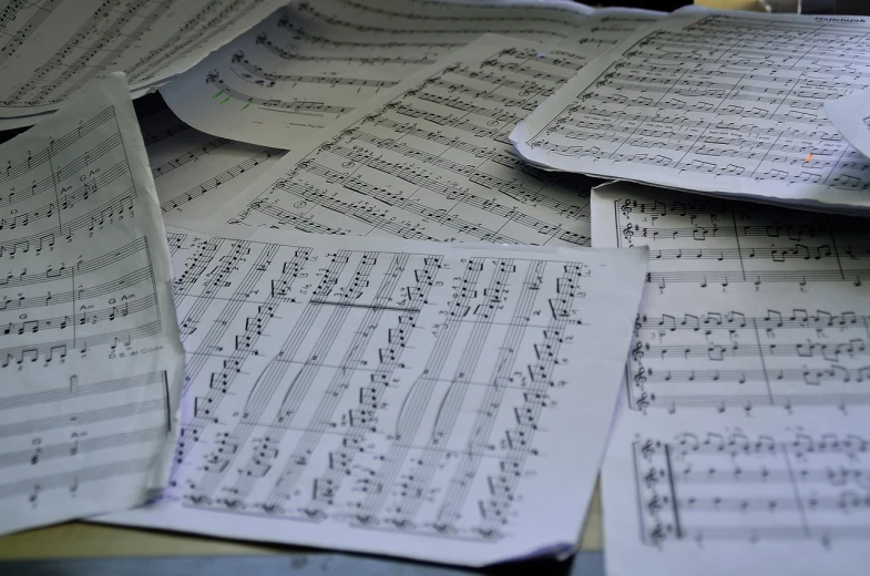 a pile of sheet music sitting on top of a table, a photo, precisionism, orchestra, messy lines, set photo, 3 4 5 3 1