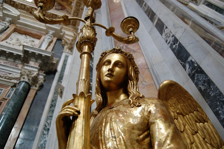 a golden statue of an angel holding a lamp, a statue, by Andrea del Verrocchio, flickr, interior of the old cathedral, made of polished broze, torri, the photo shows a large