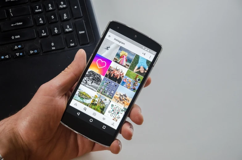 a person holding a smart phone in front of a laptop, featured on instagram, happening, colorful digital screens) xf iq4, album photo, android, istockphoto