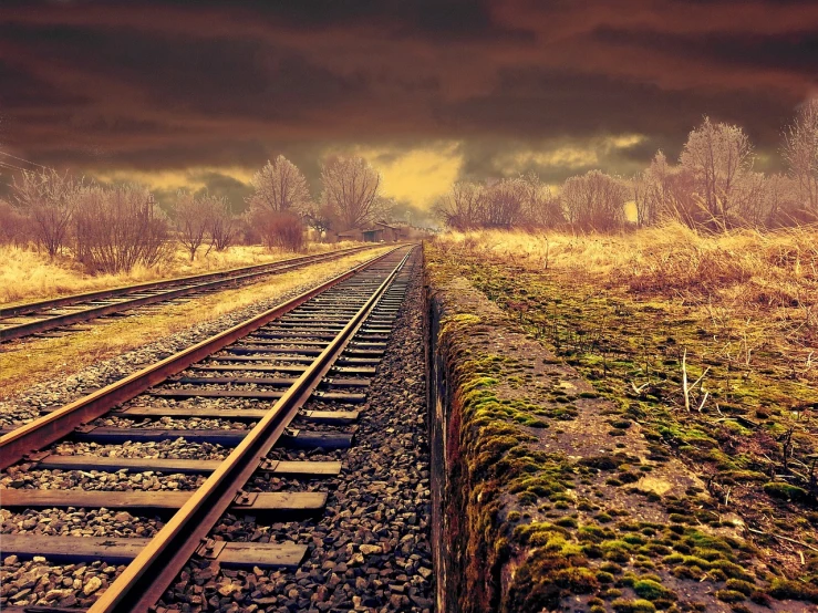 a train track with a cloudy sky in the background, a picture, trending on pixabay, realism, background image, deep colours. ”, desolated wasteland, springtime morning