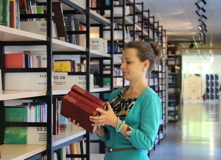 a woman reading a book in a library, academic art, inspect in inventory image, espoo, holding a book, regale