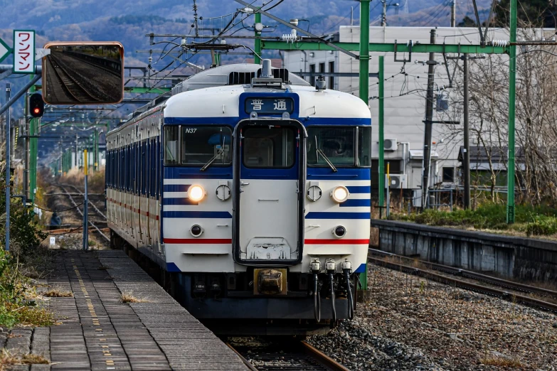 a blue and white train traveling down train tracks, sōsaku hanga, symmetrical front view, 4 0 0 mm f 1. 8, seifuku, high resolution!!